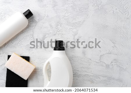 Set of different bottles of detergents top view on grey background