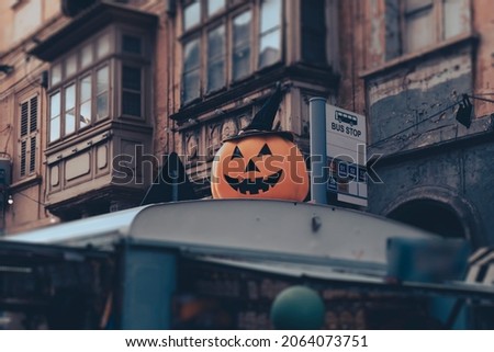 Big smiling pumpkin in hat on roof of street food truck during Halloween holiday as decoration on Malta street