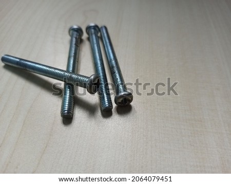 four iron bolts on a wooden texture table