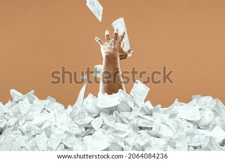 A man's hand sticks out of a mountain of checks and bills. A man is drowning in debt, credit, mortgage, loan, mortgage Royalty-Free Stock Photo #2064084236