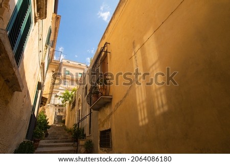 City landscape of old Sicilian Modica city. Sandstone houses, stairway and balconies, courtyards with nobody inside. Bright sunny photo good for touristic booklets, travel company website etc.