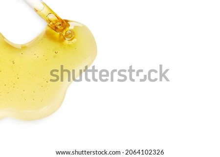 Yellow texture of a drop of whey or olive oil on a white background. Transparent sample of cosmetic gel with bubbles. Golden acid cream. Vitamin c. A drop of honey. Hyaluronic acid. Royalty-Free Stock Photo #2064102326