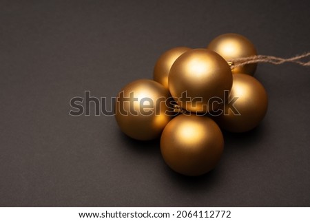 A bunch of gold Christmas balls on a dark background