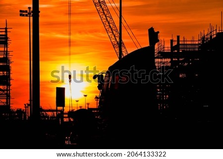 Silhouette photo during sunset, building construction in Laem Chabang deep sea port, Thailand.