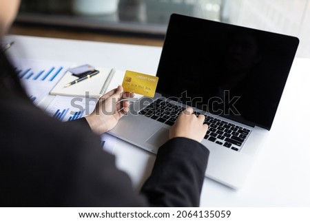 Businesswoman holding a credit card and using a laptop. Conduct online financial transactions concept. Online shopping.