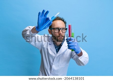 Scientific experiment. Close-up young chemist, doctor conducts chemical research isolated on white background. Concept of healthcare, pharmaceuticals, medicine. Copy space for ad. Looks serious Royalty-Free Stock Photo #2064138101