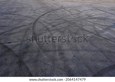 Aerial top view abstract texture and background of car tire drift skid mark on road race track, Black tire mark on street race track, Automobile and automotive concept. Royalty-Free Stock Photo #2064147479