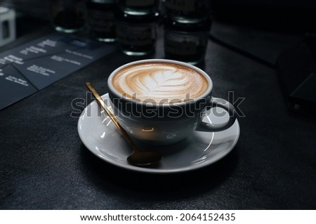 Close up hot cappuccino white coffee cup with heart shape latte art on dark table at caff food and drink concept.