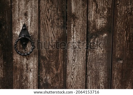 Old vintage textured wood door with ring door lock. Old brown wooden door with metal lock