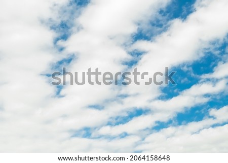 Beautiful blue sky with long longitudinal white clouds.