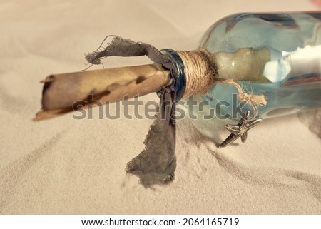 Pirate's bottle on the sand, old parchment, message in a bottle
