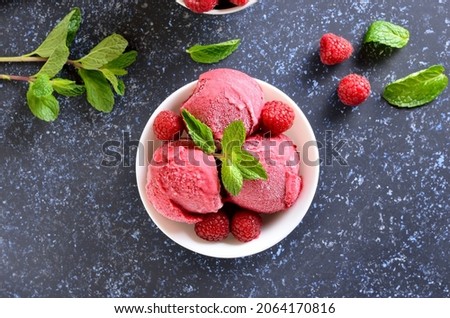 Raspberry ice cream in bowl on stone background. Top view, flat lay