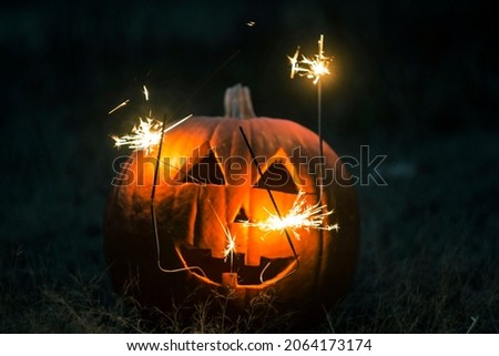 Halloween pumpkin in october night. sparkler.
