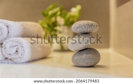 Zen stones, smooth pebbles pyramid stacked balance, spa interior background. Holistic natural therapy and wellness concept