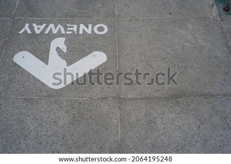 a symbol indicating a one-way street on a sidewalk