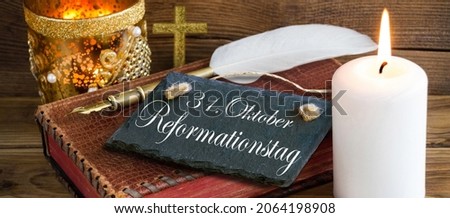 German Reformation Day October 31 and bible with cross and white burning candle