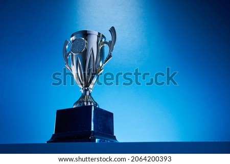 low angle view of winning trophy against blue background Royalty-Free Stock Photo #2064200393