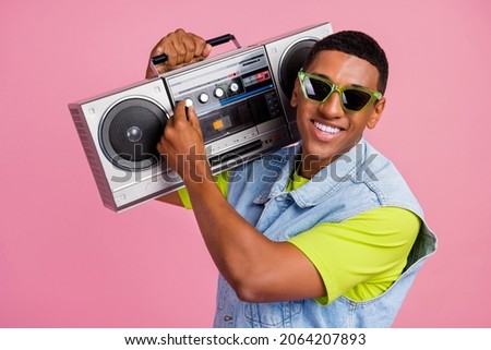 Photo of cool millennial guy with boom box wear eyewear vest t-shirt jeans isolated on pink background Royalty-Free Stock Photo #2064207893