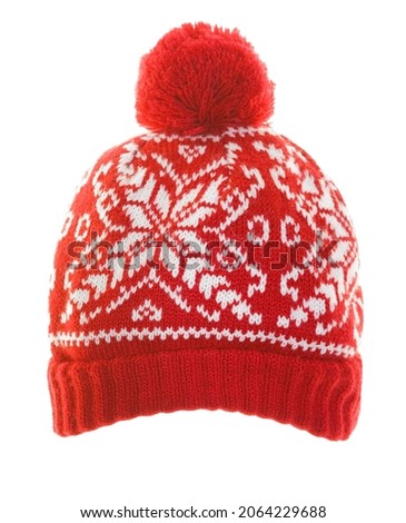 red knitted hat with  snowflakes pattern on surface. winter beanie  isolated on white background. wintertime season. cap with pompom