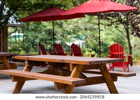 Picnic table on campground with red chair and umbrella