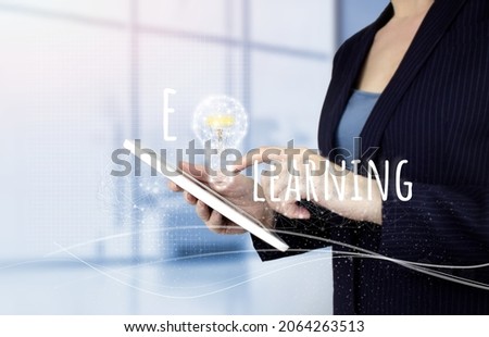 Online education. E-learning and e-book concept. Education and online learning media. Hand touch white tablet with digital hologram light bulp sign on light blurred background
