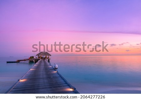 Stunning colorful sunset sky with clouds seaside horizon. Lagoon landscape in Maldives. Luxury traveling destination, exotic summer beach view. Tropical vacation and summer holiday background concept Royalty-Free Stock Photo #2064277226