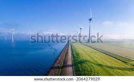 offshore windmill park with clouds and a blue sky, windmill park in the ocean aerial view with wind turbine Flevoland Netherlands Ijsselmeer. Green energy  Royalty-Free Stock Photo #2064279029