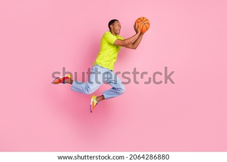 Full size profile photo of cool young brunet guy play basketball wear t-shirt jeans gumshoes isolated pink background