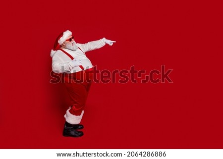 Profile photo of funky man laugh direct finger empty space sale wear santa hat costume isolated red color background