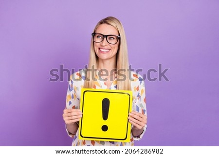 Photo of charming dreamy mature lady dressed print blouse glasses looking empty space holding danger card isolated purple color background