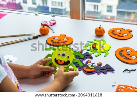 Cuts of paper for Halloween. Hand cut paper. Pumpkins. Scissors and glue. On a light background. Top view. Flat lay. DIY. Step by step