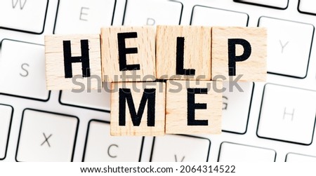 HELP ME. The word HELP ME made of wooden letters located on a white computer keyboard