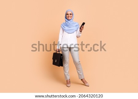Full size photo of young arabic trend ceo lady with bag wear headscarf shirt eyewear pants stilettos isolated on peach background