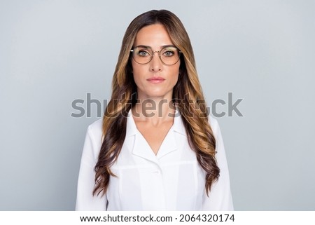 Photo of mature serious brown hairdo lady wear eyewear white nurse coat isolated on grey background