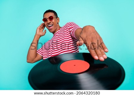Photo of charming handsome young man wear striped t-shirt smiling playing music isolated teal color background Royalty-Free Stock Photo #2064320180
