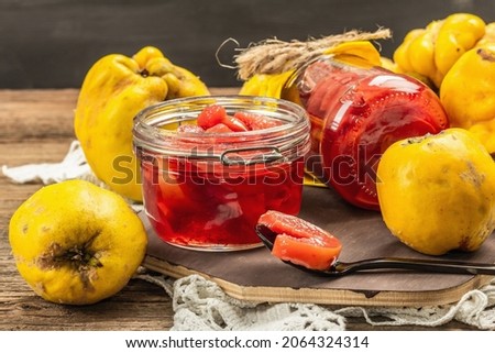 Homemade quince jam in a glass jar. Fresh fruits, sweet marmalade,vintage arrangement. Old wooden background, close up Royalty-Free Stock Photo #2064324314