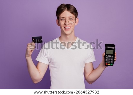 Photo of young guy hold credit card terminal atm money customer buy isolated on violet color background