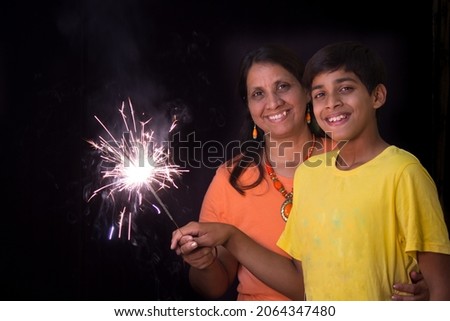 Mother and Son enjoying the sparkle fireworks as part of Diwali festival celebrations in India with copy space 