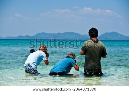 Tourists taking pictures of fish at the sea 