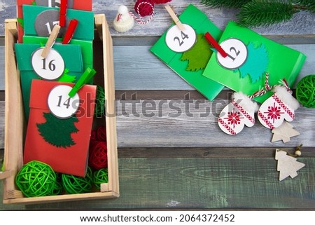 Christmas Advent calendar on the table, in a wooden box. Multicolored envelopes made by hand