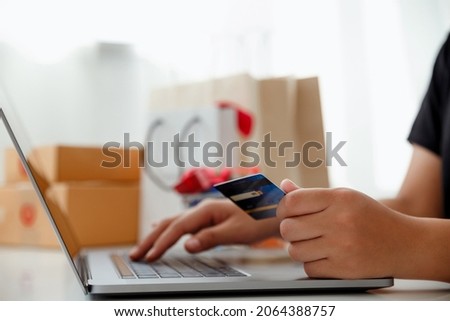 Woman hands holding credit card and using a laptop.Ideas about online shopping addiction.Online shopping concept.Black Friday.

