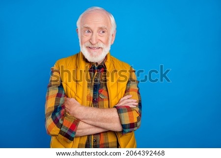 Portrait of attractive cheerful grey-haired man folded arms thinking copy space place isolated over bright blue color background
