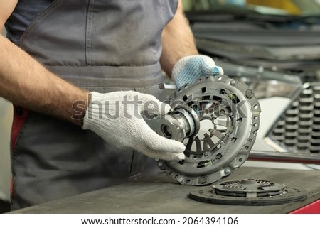 Spare parts for cars. Car clutch kit. The car mechanic monitors the technical condition of the drive disc, the driven disc and the exhaust bearing. Royalty-Free Stock Photo #2064394106