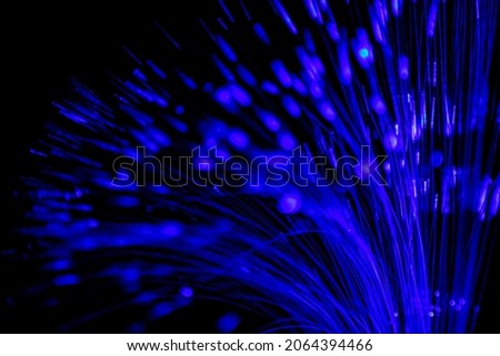 Close up of blurred light fiber optics for communication technology network on black background