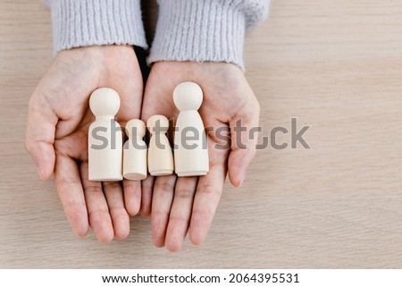 Close up of young women holding people shape male and female doll wooden peg dolls, family day, warmth, happiness, life insurance concept. Royalty-Free Stock Photo #2064395531