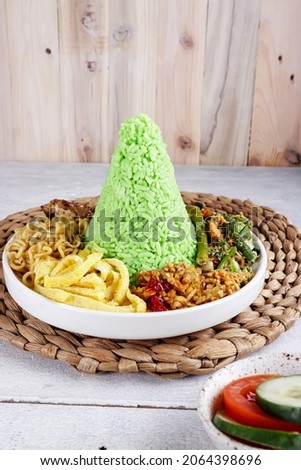 Nasi Tumpeng Pandan is dome shape pandan green rice with various side dish. Royalty-Free Stock Photo #2064398696