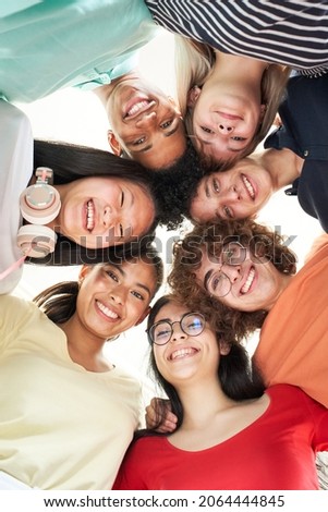 Vertical photo of a multiracial group of friends taking a selfie - New concept of normal friendship with young people looking at the camera and laughing.