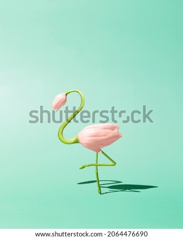 Contemporary art still life concept. Flamingo made from pink tulip flowers. Spring and summer green background. Flamingos Lover