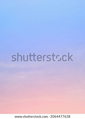 The background of the sky with natural clouds on the gentle twilight atmosphere with pastel rainbow gradations blends orange, pink, purple and blue like subtle, and the faded white mist blur adds soft
