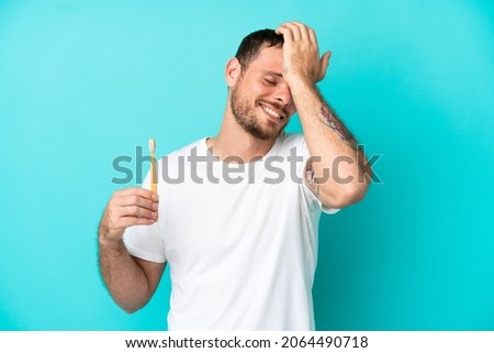 Young Brazilian man brushing teeth isolated on blue background has realized something and intending the solution
